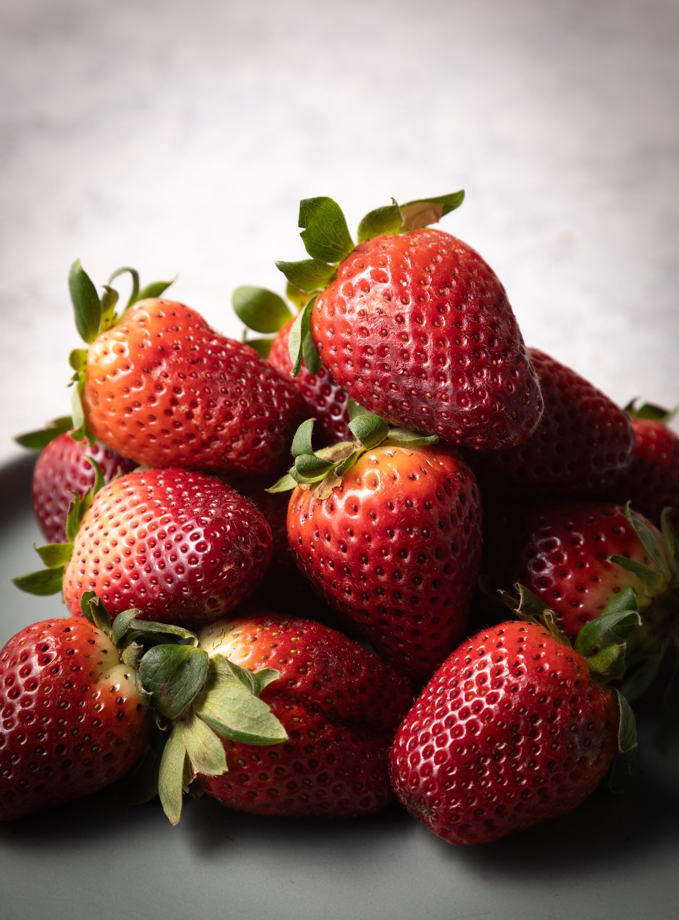 A photograph of a pile of fresh red juicy  strawberries.